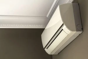 Cool air conditioner system on dark wall in room interior